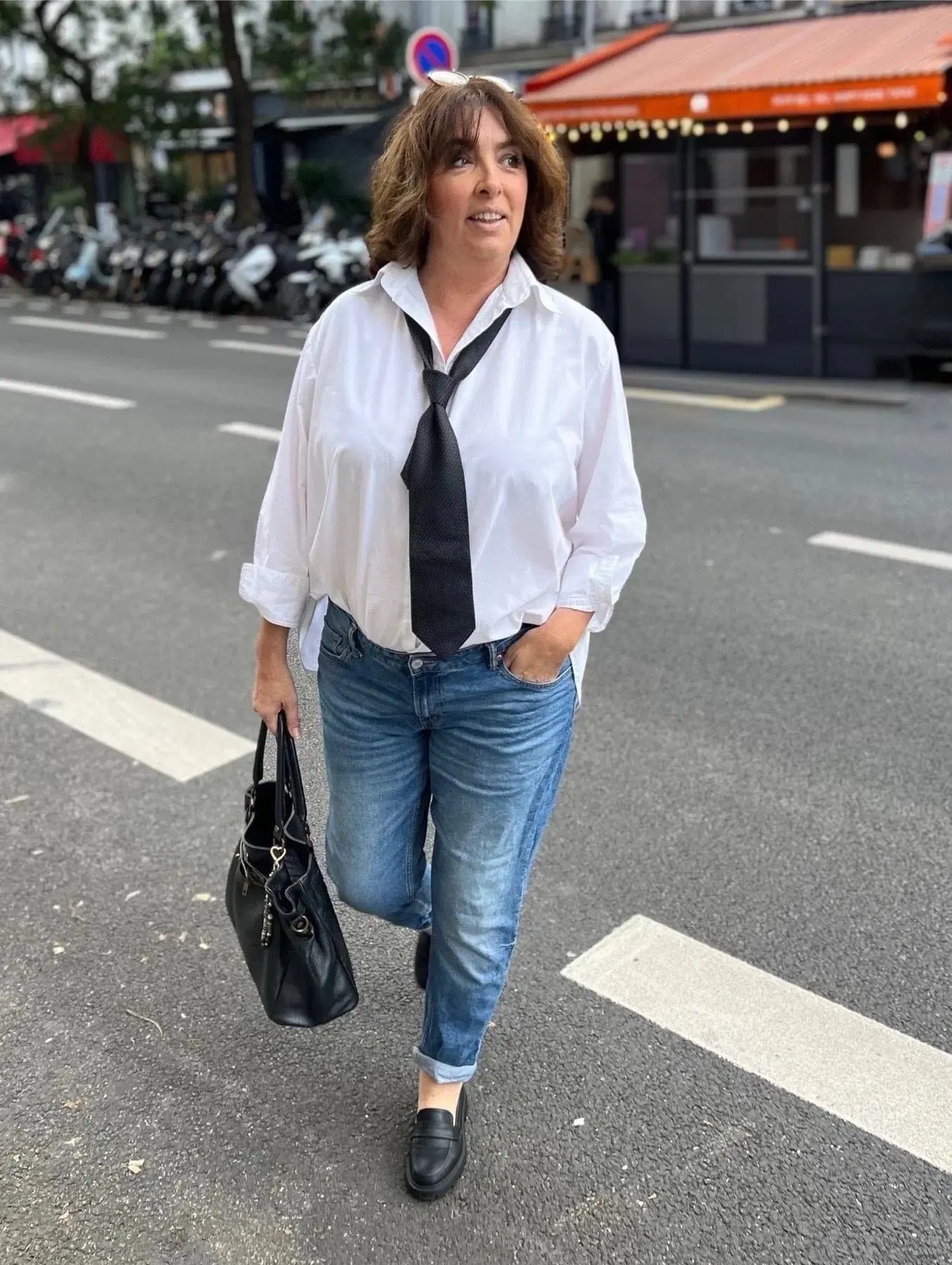 Chemise blanche grande taille femme portée à l'intérieur d'un jean et avec unce cravate