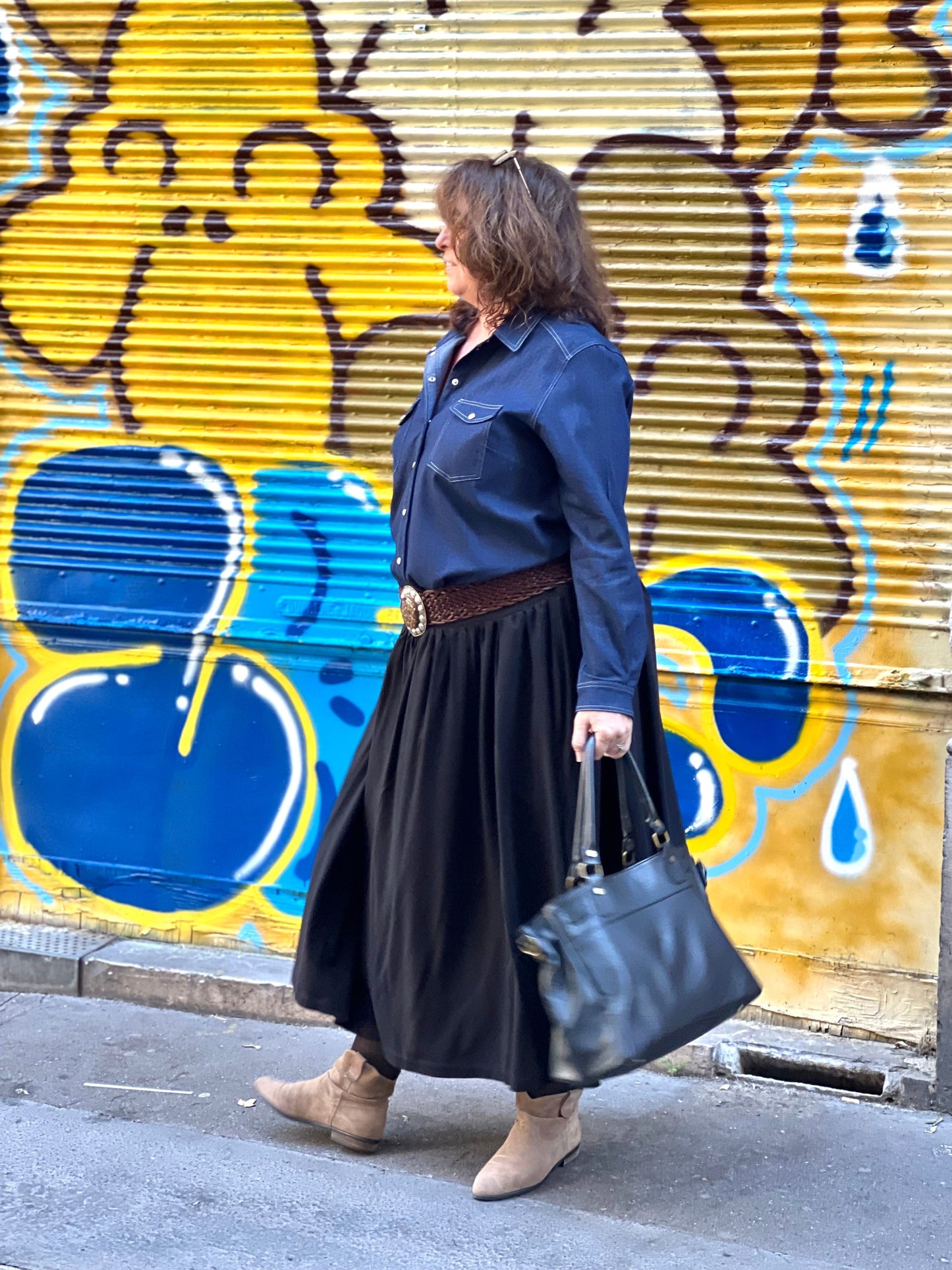 Chemise jean grande taille femme portée avec une jupe, profil - Les Militantes