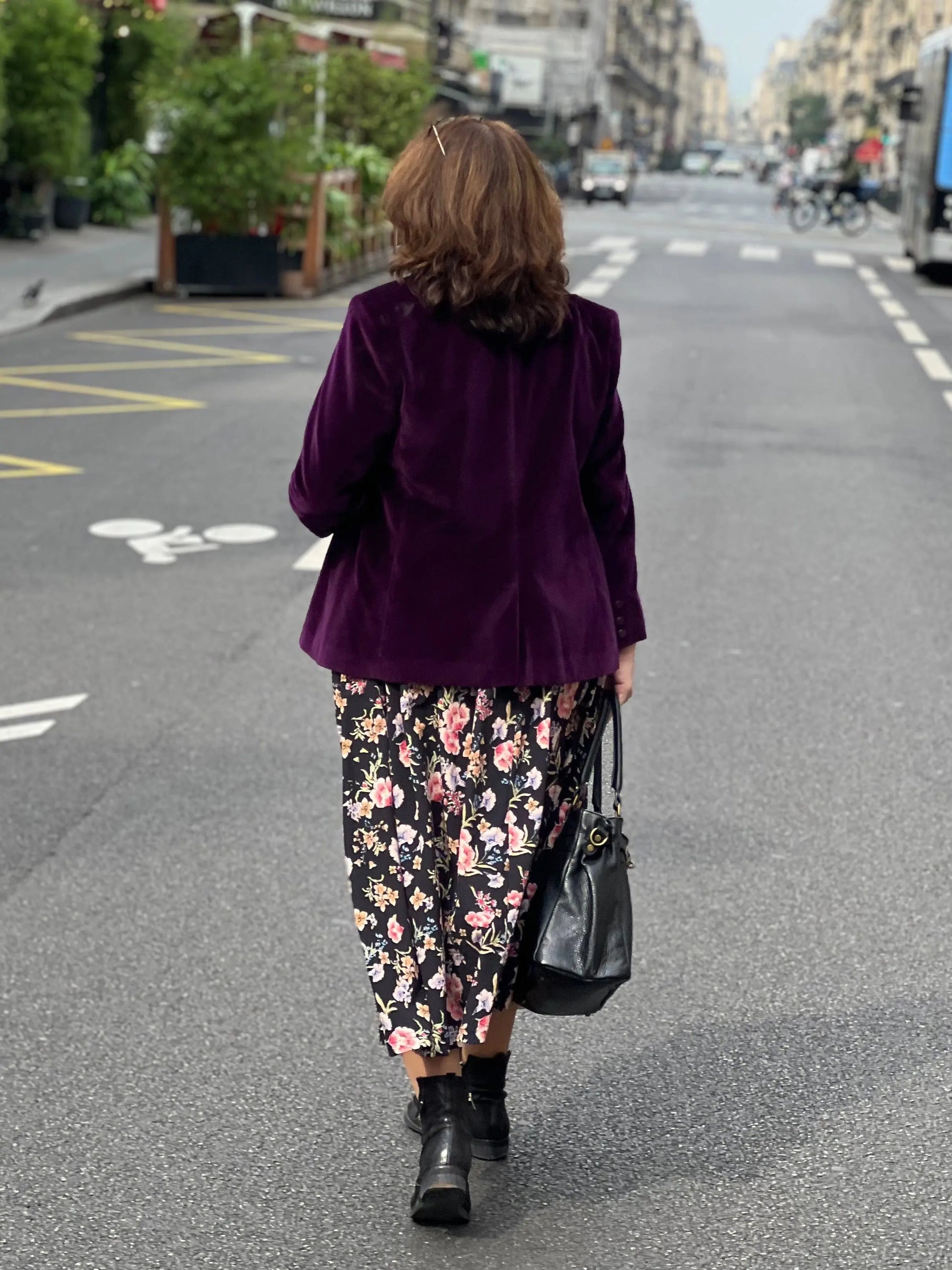 Jupe longue grande taille imprimé floral portée avec un blazer en velours couleur prune. Vue de dos