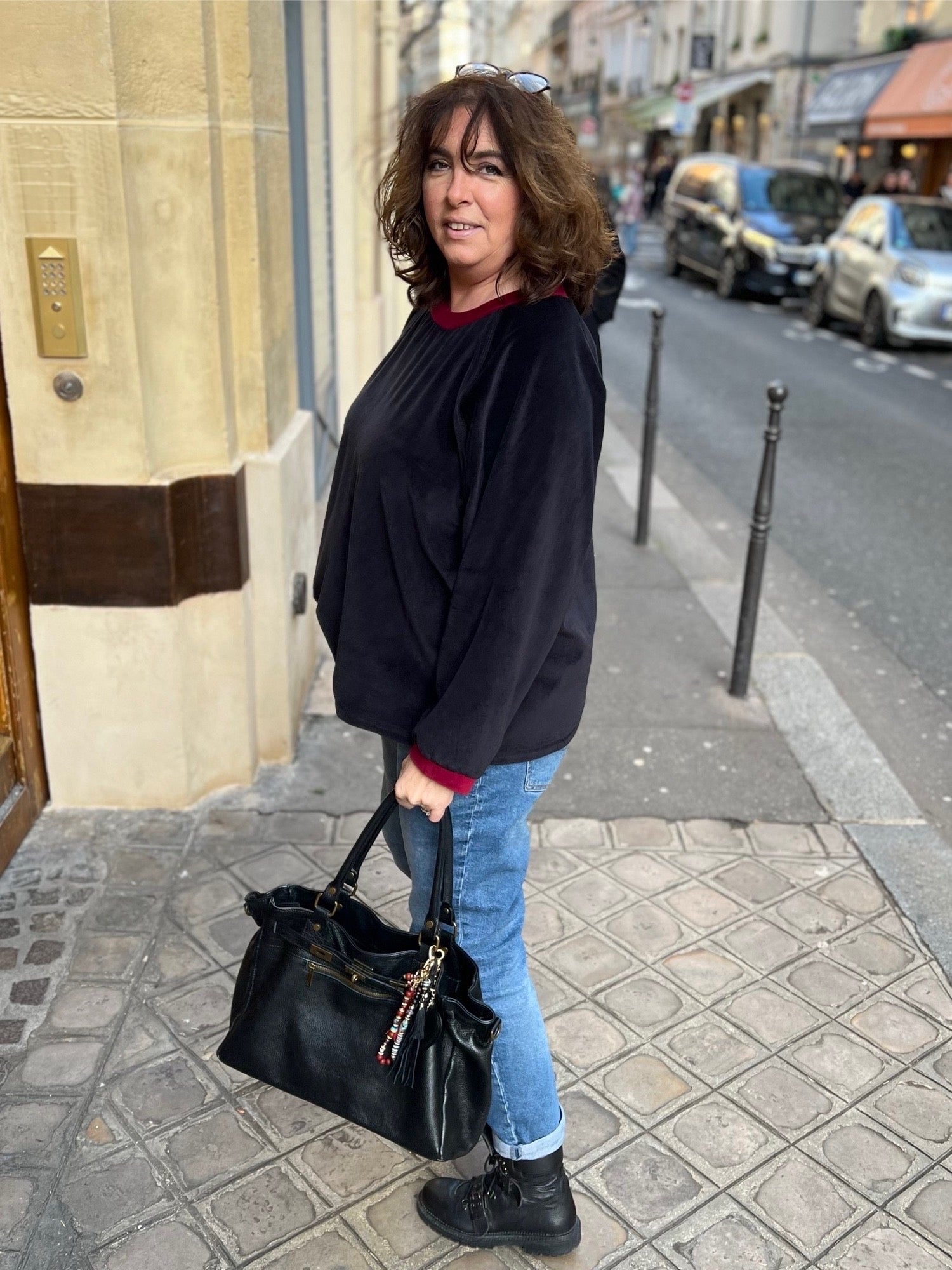 sweat grande taille en velours pour femme. Noir avec cool et poigents rouges. De profil