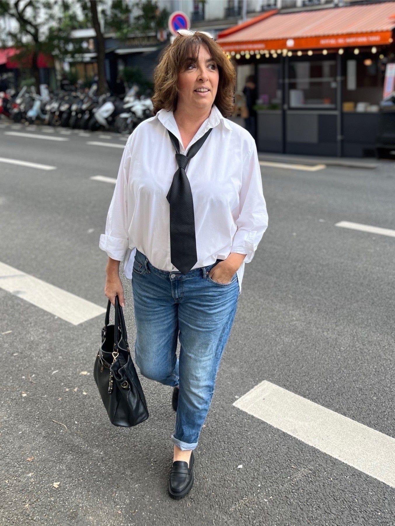 Chemise blanche grande taille femme portée à l'intérieur d'un jean et avec unce cravate